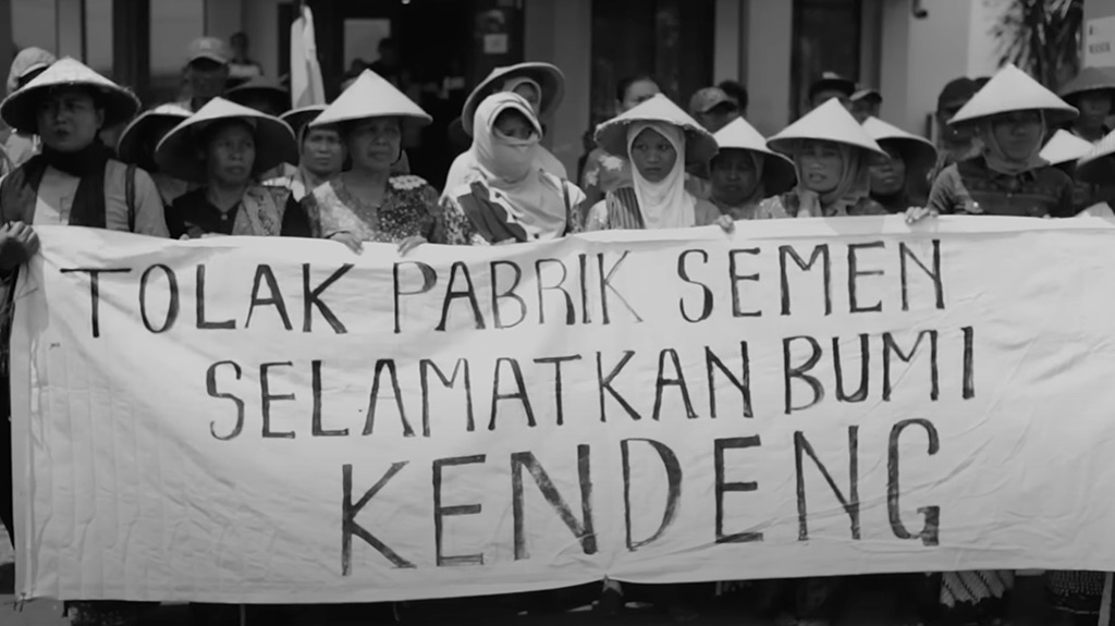 A still from Navicula’s Kartini music video, the protest sign reads “Refuse the cement factory, save the Kendeng earth”